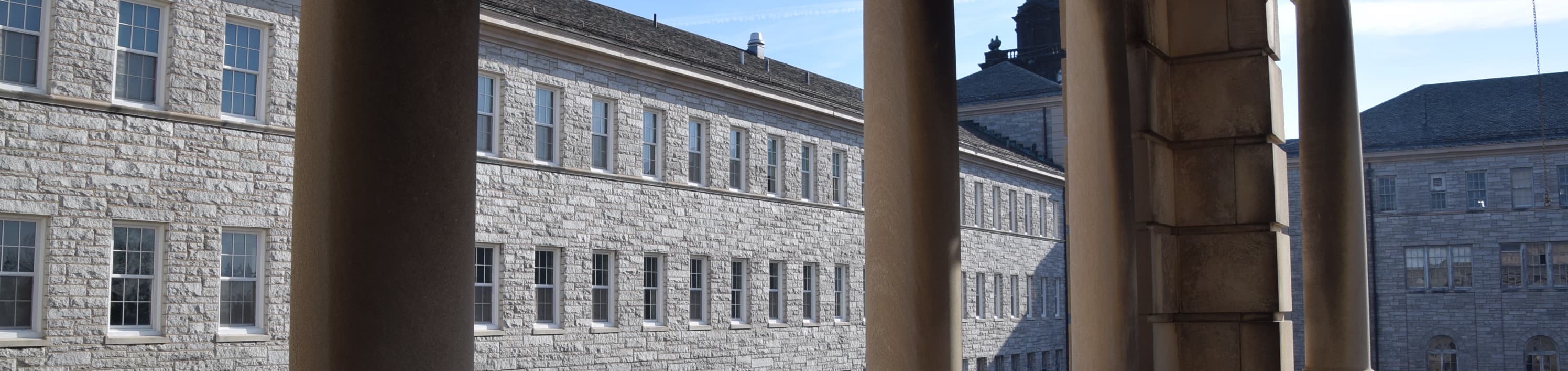 columns of a balcony with an old building in the background