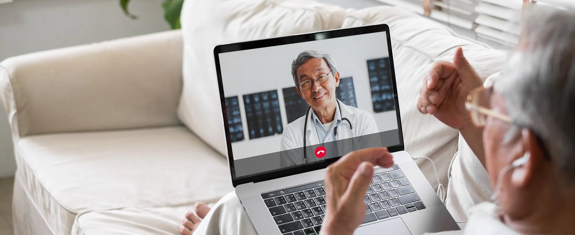 image of an elderly person speaking to their doctor via a video call on their computer